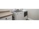 Clean laundry room with front loading washer and dryer, plus a folding counter at 14160 Ivanhoe St, Thornton, CO 80602