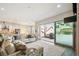 Open-concept living room with sliding glass doors, a stone fireplace, and a seamless connection to the kitchen at 14160 Ivanhoe St, Thornton, CO 80602
