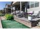 Outdoor patio features comfortable lounge seating, artificial turf, and lush landscaping at 14160 Ivanhoe St, Thornton, CO 80602