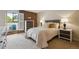 Bright bedroom features exposed brick, a comfortable bed, and neutral-toned carpet at 2880 S Locust St # 305N, Denver, CO 80222