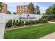 Landscaped community sign for Plaza de Monaco with a lush green lawn and surrounding foliage at 2880 S Locust St # 305N, Denver, CO 80222
