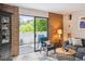 Relaxing living room with a blue chair, brick accent wall, and sliding doors opening to the outside at 2880 S Locust St # 305N, Denver, CO 80222