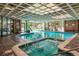 Inviting indoor pool area featuring a hot tub, brick accents and lots of natural light from the large windows at 2880 S Locust St # 305N, Denver, CO 80222