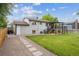Well-maintained backyard with a covered deck, patio, and stone pathway at 2843 S Otis St, Denver, CO 80227