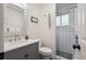 Bathroom with white tile shower, grey vanity, white countertops, modern fixtures, and stylish decor at 2843 S Otis St, Denver, CO 80227