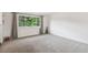 Open-plan living room with a large window, soft carpet, and modern decor at 2843 S Otis St, Denver, CO 80227