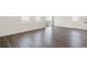 Open living space featuring gray wood floors, bright windows, and sliding glass doors, seamlessly connecting indoors and outdoors at 27674 E Byers Ave, Aurora, CO 80018