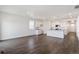 Bright, open living area with gray wood floors and white kitchen featuring stainless steel appliances at 27674 E Byers Ave, Aurora, CO 80018