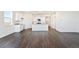 Spacious open floor plan featuring gray wood floors, flowing into a bright kitchen with white cabinets at 27674 E Byers Ave, Aurora, CO 80018