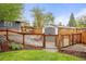 Fenced backyard with a shed, gate, and mature trees, offering privacy and storage solutions at 6742 Marshall St, Arvada, CO 80003