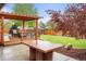 Backyard featuring a patio with pergola, stone table, grassy lawn, and trampoline for outdoor enjoyment at 6742 Marshall St, Arvada, CO 80003