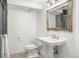 Bathroom with pedestal sink, updated lighting, tile floors and toilet at 6742 Marshall St, Arvada, CO 80003