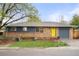 Charming brick home with a well-manicured lawn and a bright yellow front door, offering great curb appeal at 6742 Marshall St, Arvada, CO 80003
