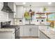 Bright and modern kitchen with granite countertops, stainless steel appliances, and sleek white cabinetry at 6742 Marshall St, Arvada, CO 80003