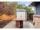 Backyard shed with double doors and a stone table, ideal for storage and outdoor activities at 6742 Marshall St, Arvada, CO 80003
