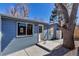 Back of light blue single-story home with new fence and trees at 10025 W 8Th Ave, Lakewood, CO 80215