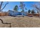 Fenced backyard with a concrete patio and lush landscaping, perfect for outdoor entertaining at 10025 W 8Th Ave, Lakewood, CO 80215