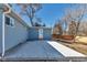 Side of a light blue single-story home with newly poured concrete patio at 10025 W 8Th Ave, Lakewood, CO 80215