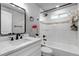Updated bathroom features sleek vanity, modern fixtures, shower over tub and decorative tile details at 10025 W 8Th Ave, Lakewood, CO 80215