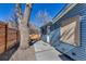 Side view of home with blue siding, a concrete patio, and a fenced yard at 10025 W 8Th Ave, Lakewood, CO 80215