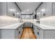 Bright kitchen featuring gray cabinets, hardwood floors, stainless appliances, and quartz countertops at 10025 W 8Th Ave, Lakewood, CO 80215