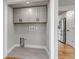 Well-designed laundry room with grey tile flooring, cabinetry, and stainless steel appliances in the background at 10025 W 8Th Ave, Lakewood, CO 80215