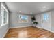 The living room has hardwood floors, white trim, and a large window looking out to the front yard at 10025 W 8Th Ave, Lakewood, CO 80215