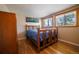 Cozy bedroom with hardwood floors, two windows, and a decorative wall art at 885 Balsam St, Lakewood, CO 80214