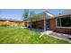 Brick home featuring a covered patio with metal support posts and a concrete floor, creating a nice outdoor living area at 885 Balsam St, Lakewood, CO 80214