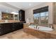 This bathroom is complete with double sinks, a large mirror, and a soaking tub near a large window at 14582 Homestead Pl, Broomfield, CO 80023