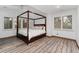A primary bedroom showcasing a four-poster bed, wood floors, and bright natural light at 14582 Homestead Pl, Broomfield, CO 80023