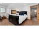 This bedroom showcases a dark wood sleigh bed with bright white linens, an adjacent bathroom, and a warm, neutral color palette at 14582 Homestead Pl, Broomfield, CO 80023