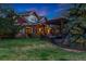 Exterior of home with sprawling lawn, backyard fire pit, and custom landscaping in the evening at 14582 Homestead Pl, Broomfield, CO 80023