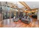 Bright living room offers expansive windows, hardwood floors, a comfortable sofa, and wooden beam accents at 14582 Homestead Pl, Broomfield, CO 80023