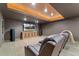 Cozy living room with a tray ceiling and a large TV and seating area at 14582 Homestead Pl, Broomfield, CO 80023