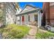 Charming home featuring a welcoming porch, vibrant red door, and well-maintained front lawn at 2322 Arapahoe St, Denver, CO 80205