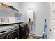 Convenient laundry area with modern washer, dryer, and ample shelving for storage at 2322 Arapahoe St, Denver, CO 80205