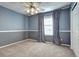 Carpeted bedroom with two-tone paint, ceiling fan, and window with decorative curtains at 3224 White Oak St, Highlands Ranch, CO 80129