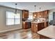 Kitchen with brown cabinets, island, stainless steel appliances and wood-style flooring at 3224 White Oak St, Highlands Ranch, CO 80129