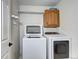 A laundry room with a front load washer and dryer and overhead shelving at 3224 White Oak St, Highlands Ranch, CO 80129