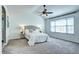 Carpeted main bedroom with a tray ceiling, ceiling fan, and large bright window at 3224 White Oak St, Highlands Ranch, CO 80129