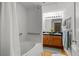 Bright bathroom with double sinks, vanity lighting, and a tub with white tile at 1745 Wazee St # 3C, Denver, CO 80202