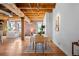 Dining room with hardwood floors, exposed wood beams, and a view into a comfortable living space at 1745 Wazee St # 3C, Denver, CO 80202