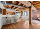 Open concept living area with kitchen island, dining and living space, exposed brick, and wood beams at 1745 Wazee St # 3C, Denver, CO 80202