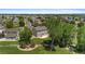 Overhead view showcases a home with a spacious lawn, patio, mature trees, and a well-kept neighborhood setting at 201 Shenandoah Way, Brighton, CO 80603