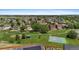 Wide aerial view of a residential area featuring a park, playground, and well-kept lawns at 201 Shenandoah Way, Brighton, CO 80603