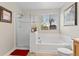 Bright bathroom featuring a soaking tub, separate shower, and a window, creating a relaxing space at 201 Shenandoah Way, Brighton, CO 80603
