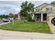 Inviting front yard showcasing a green lawn and a charming two-story home with a covered front porch at 201 Shenandoah Way, Brighton, CO 80603