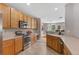 Bright kitchen featuring wooden cabinets, stainless steel appliances, and an open layout to the living spaces at 201 Shenandoah Way, Brighton, CO 80603