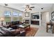 Comfortable living room with a fireplace, large windows, ceiling fan and comfortable seating at 201 Shenandoah Way, Brighton, CO 80603